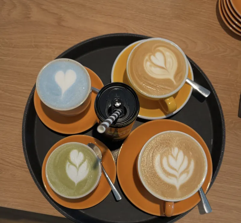 Tablett mit Cappuccino, Matcha Latte und blauem Lavendel Latte mit Latte Art